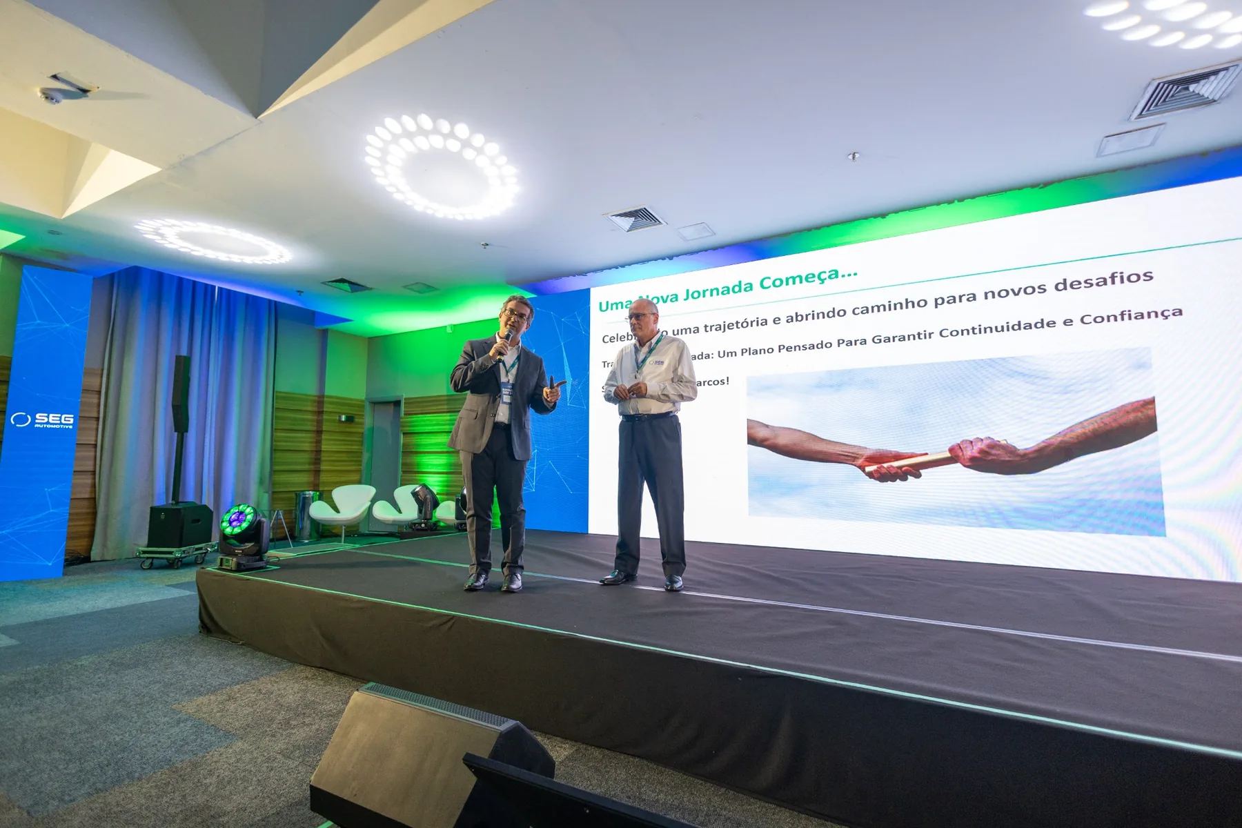 Evento corporativo com palco, público e painel